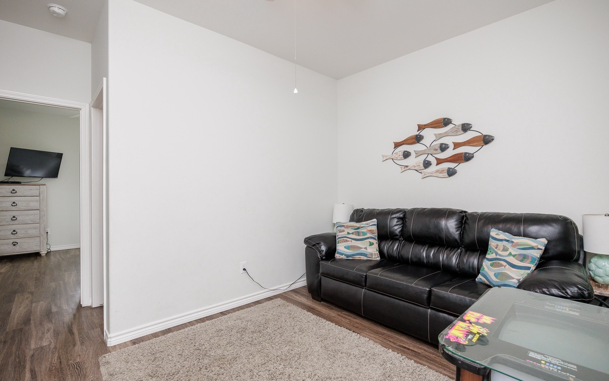 Sink into the plush leather sofa and unwind in your bright, modern living space with coastal touches and stylish decor.