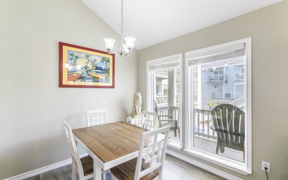 Gather around your dining table for memorable meals, with balcony doors opening to fresh air and charming views of neighboring buildings.