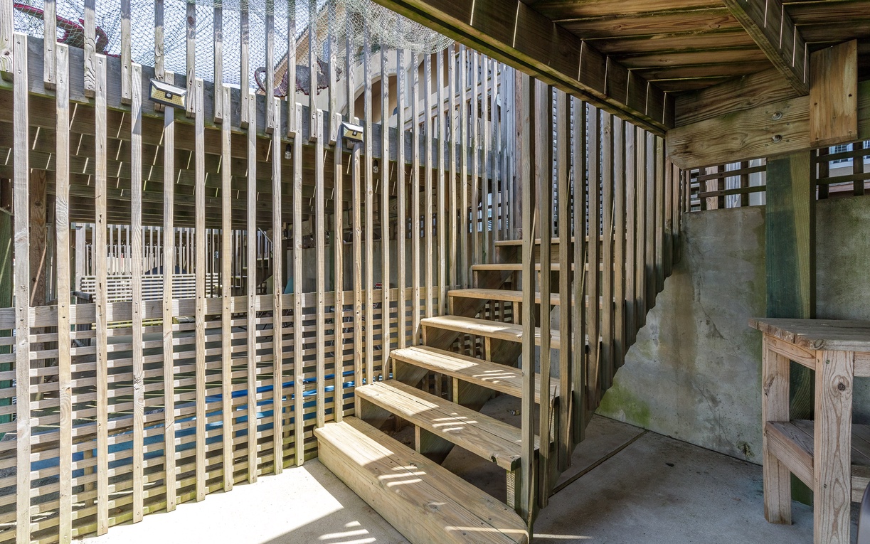 Wooden staircase leading to upper level deck with natural timber railings and rustic charm.