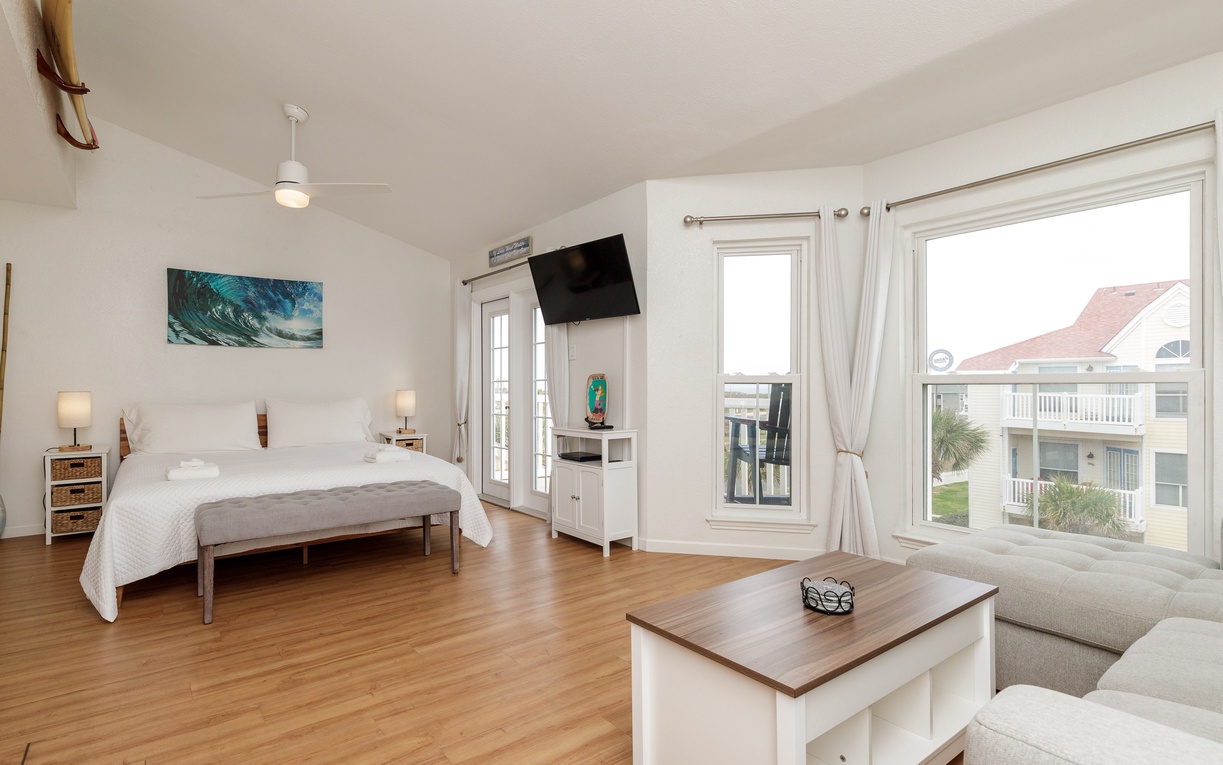 Unwind in your bright, airy suite with coastal charm, plush seating, and peaceful neighborhood views from expansive windows.