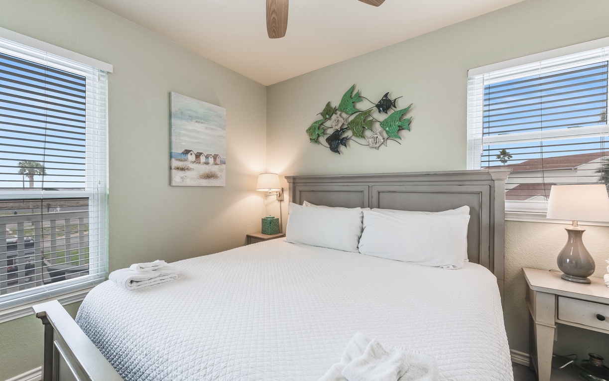 Drift off in this serene bedroom, where coastal artwork and exposed beams create your perfect retreat.
