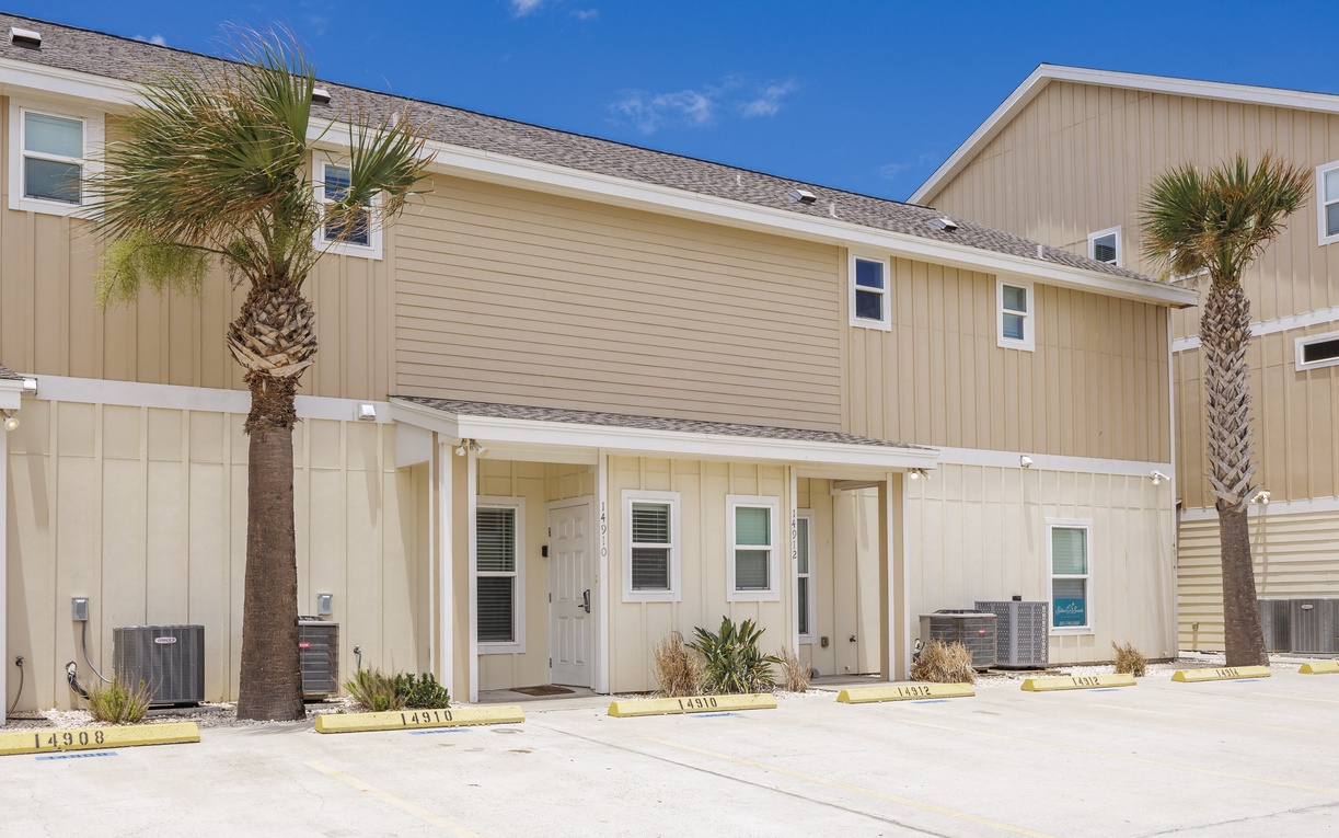 Modern beachside townhomes with coastal architecture and tropical palm trees create the perfect vacation setting.