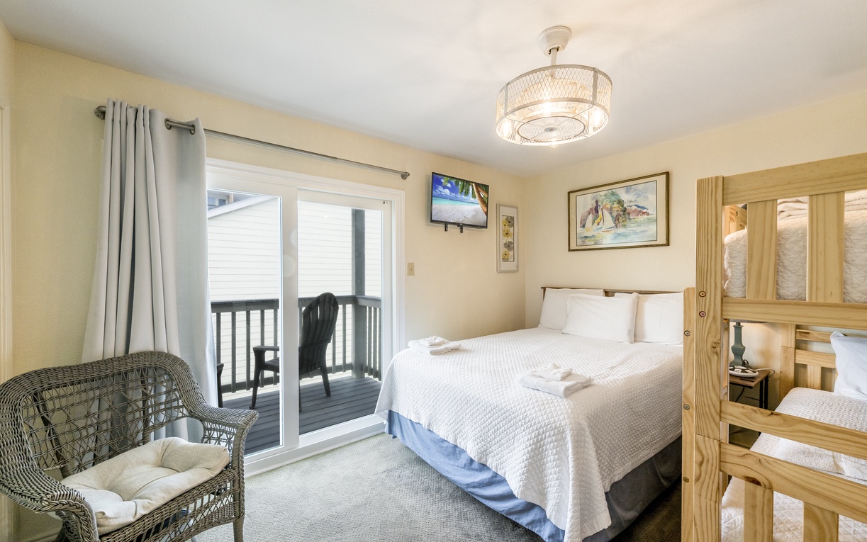 Your spacious bedroom features a comfy queen bed, twin bunk beds for kids, and sliding doors to your private balcony.