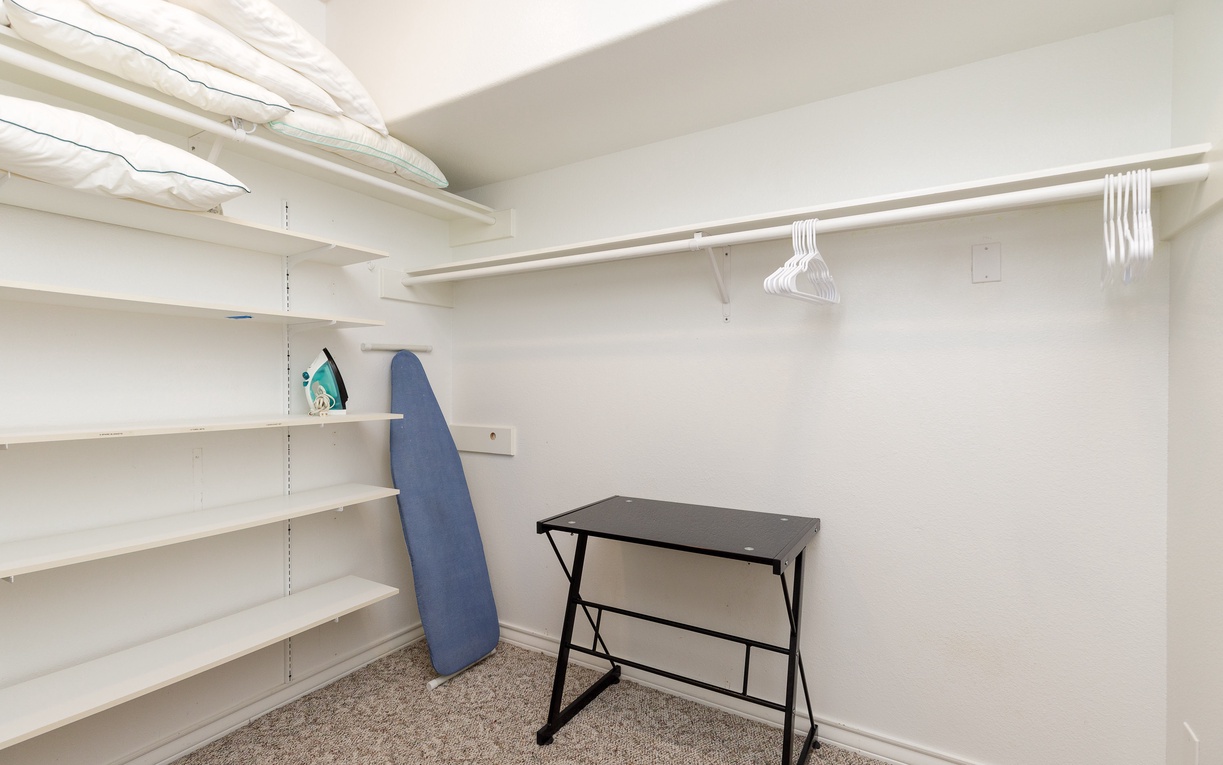 Your walk-in closet offers abundant shelving and hanging space, plus an ironing station for effortless outfit prep.