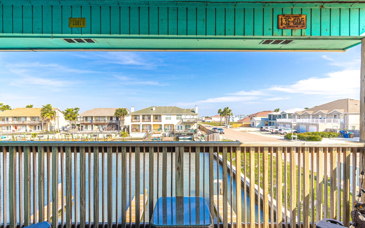 Waterfront balcony with scenic canal views of charming beach houses and boats across the water.