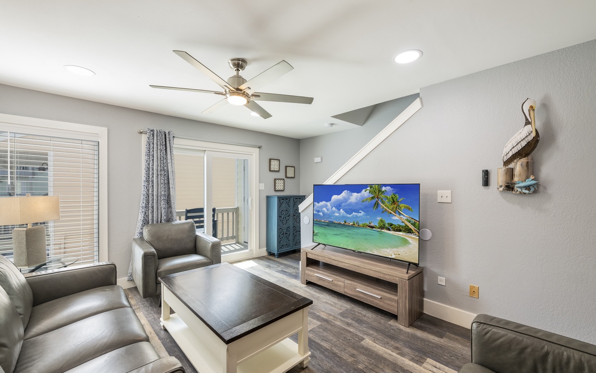 Unwind in your bright living room with plush seating, ceiling fan, and modern TV perfect for cozy evenings in.