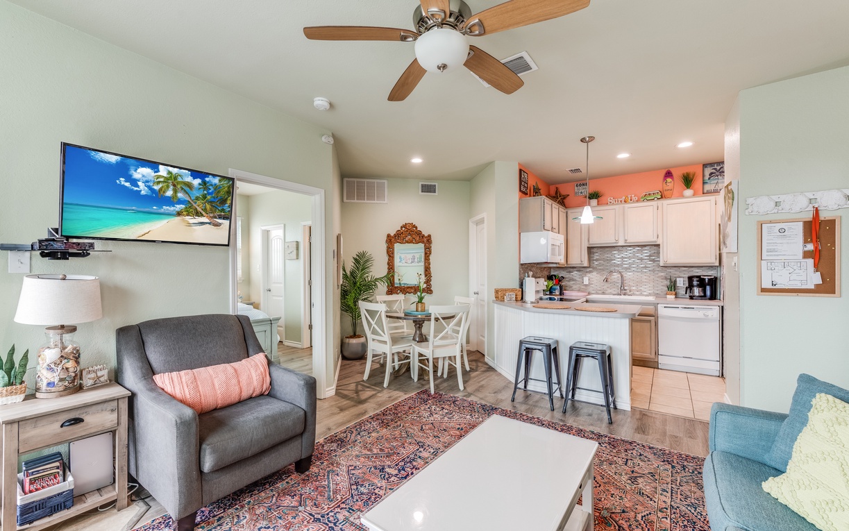 Relax in your bright, open living space where modern comfort meets coastal charm with kitchen island seating and cozy furnishings.