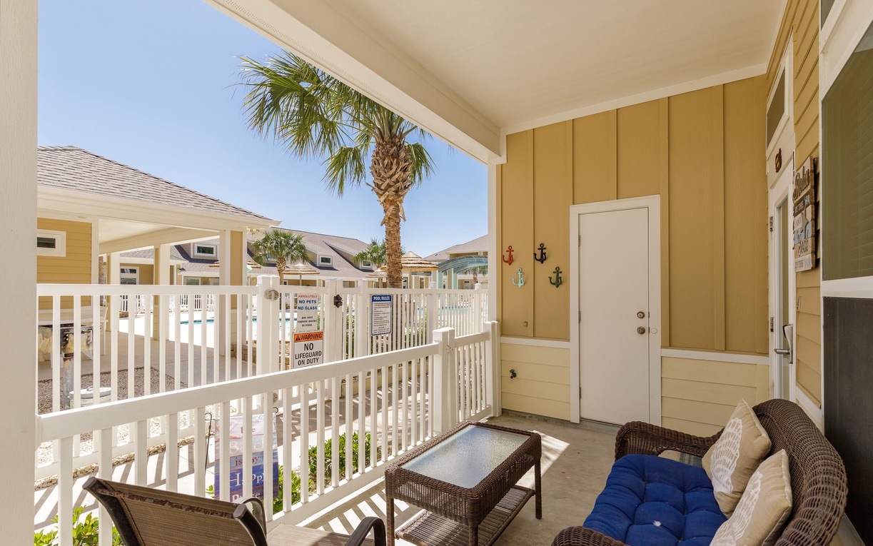 Relax on your private covered balcony with wicker seating and views of palm trees and tropical landscaping.