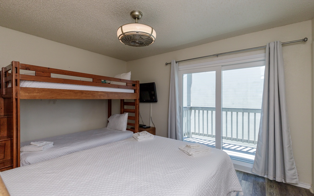 Your cozy bedroom features a comfortable queen bed and bunk bed, perfect for families. Step onto your private balcony to enjoy serene mountain views.