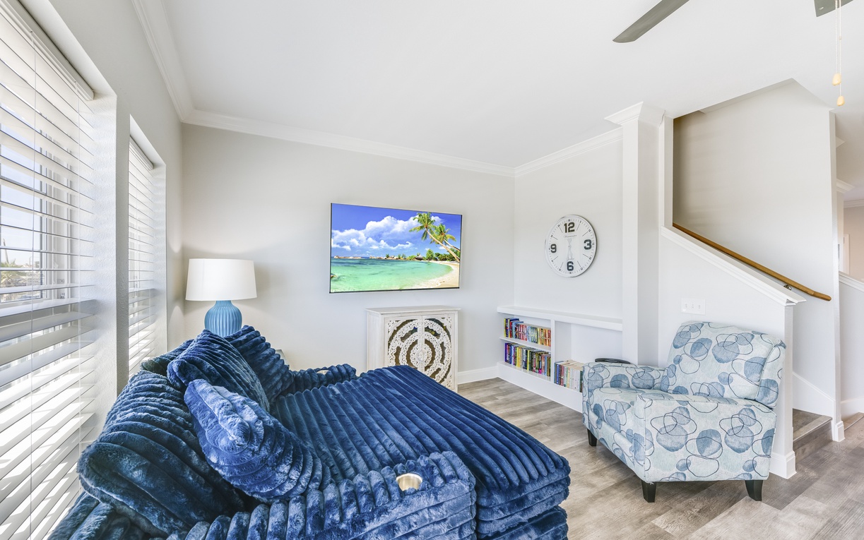 Sink into plush velvet seating while tropical scenes on your wall-mounted TV transport you to paradise in this bright, airy living space.
