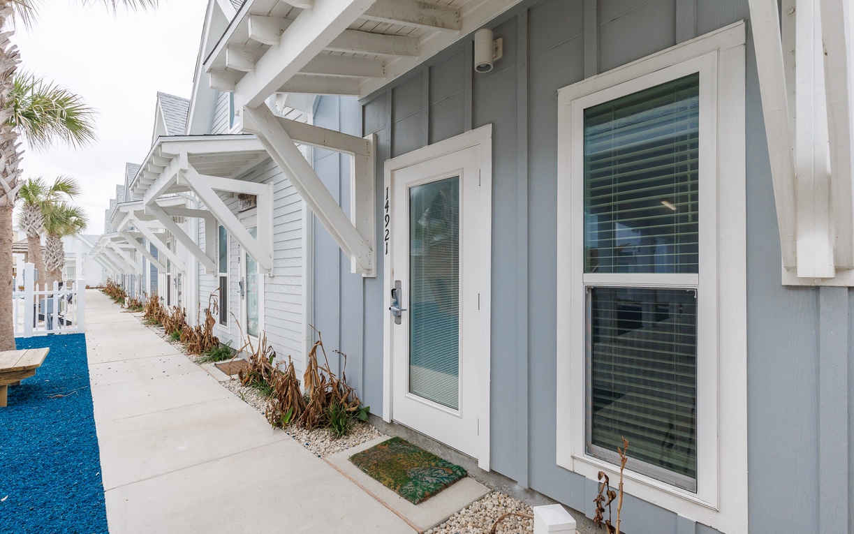 Modern coastal buildings with clean lines and tropical landscaping create an inviting beachside community atmosphere.