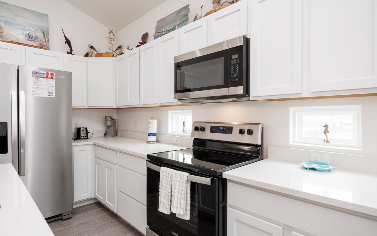 Your fully equipped kitchen awaits with modern appliances, crisp white cabinetry, and ample counter space for creating memorable meals together.