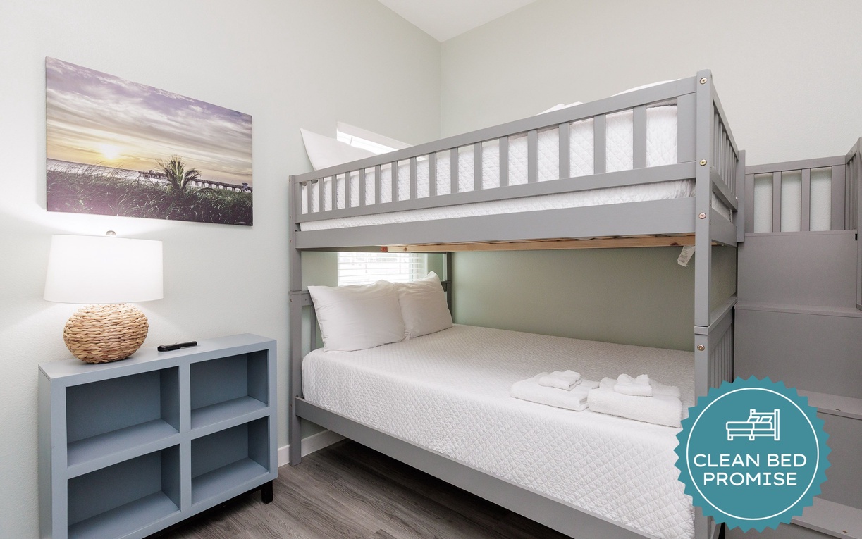 Your family will love this thoughtfully designed bunk bed room with crisp linens and coastal artwork creating a cozy retreat.