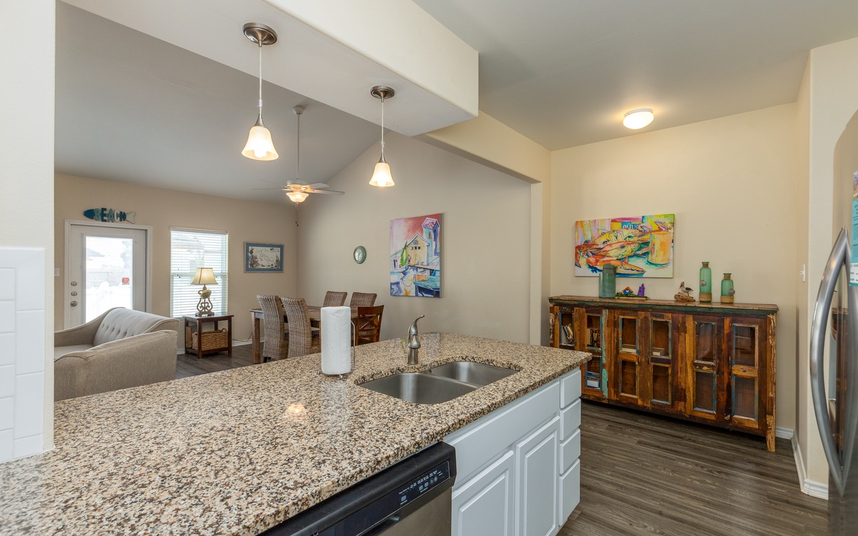 Your open kitchen flows seamlessly into the dining and living areas, perfect for entertaining with granite counters and colorful artwork.