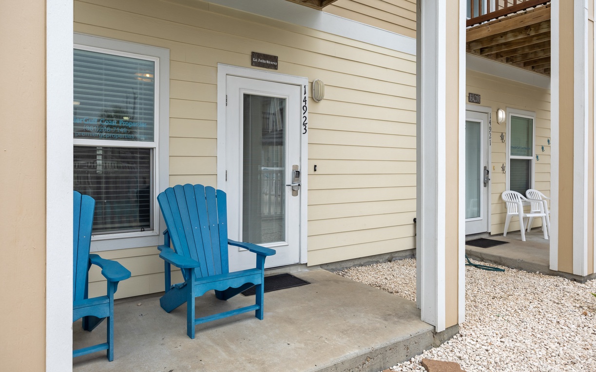 Charming entrance with bright blue Adirondack chairs on your private patio - the perfect spot to unwind after a day of exploring.