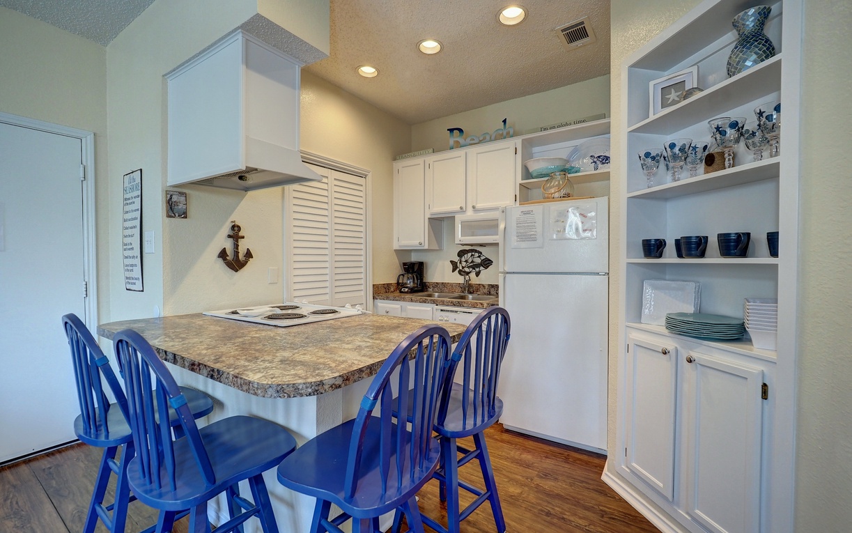 Your coastal-themed kitchen welcomes you with cheerful blue chairs, granite countertops, and nautical touches throughout this fully-equipped space.