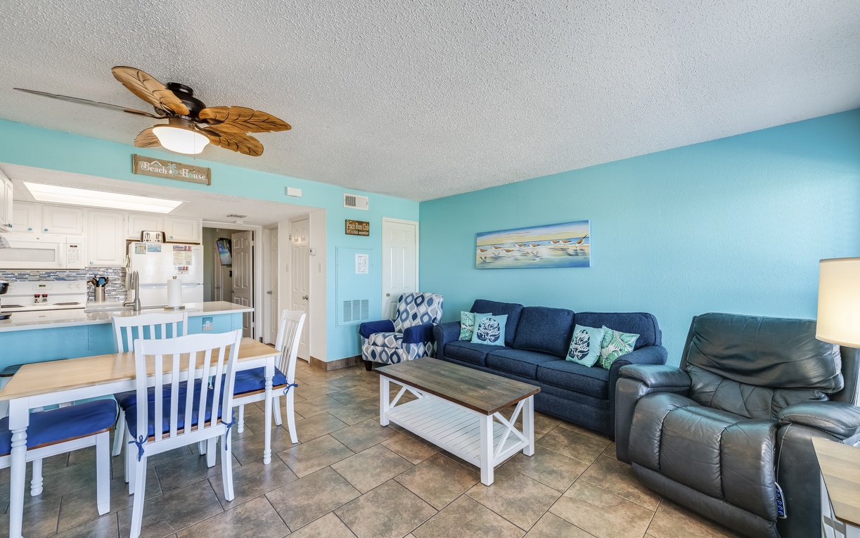 Kick back in this coastal-inspired living room featuring a plush sofa, comfy recliner, and accent chair—the perfect spot to relax after a day at the beach with dune views right outside.