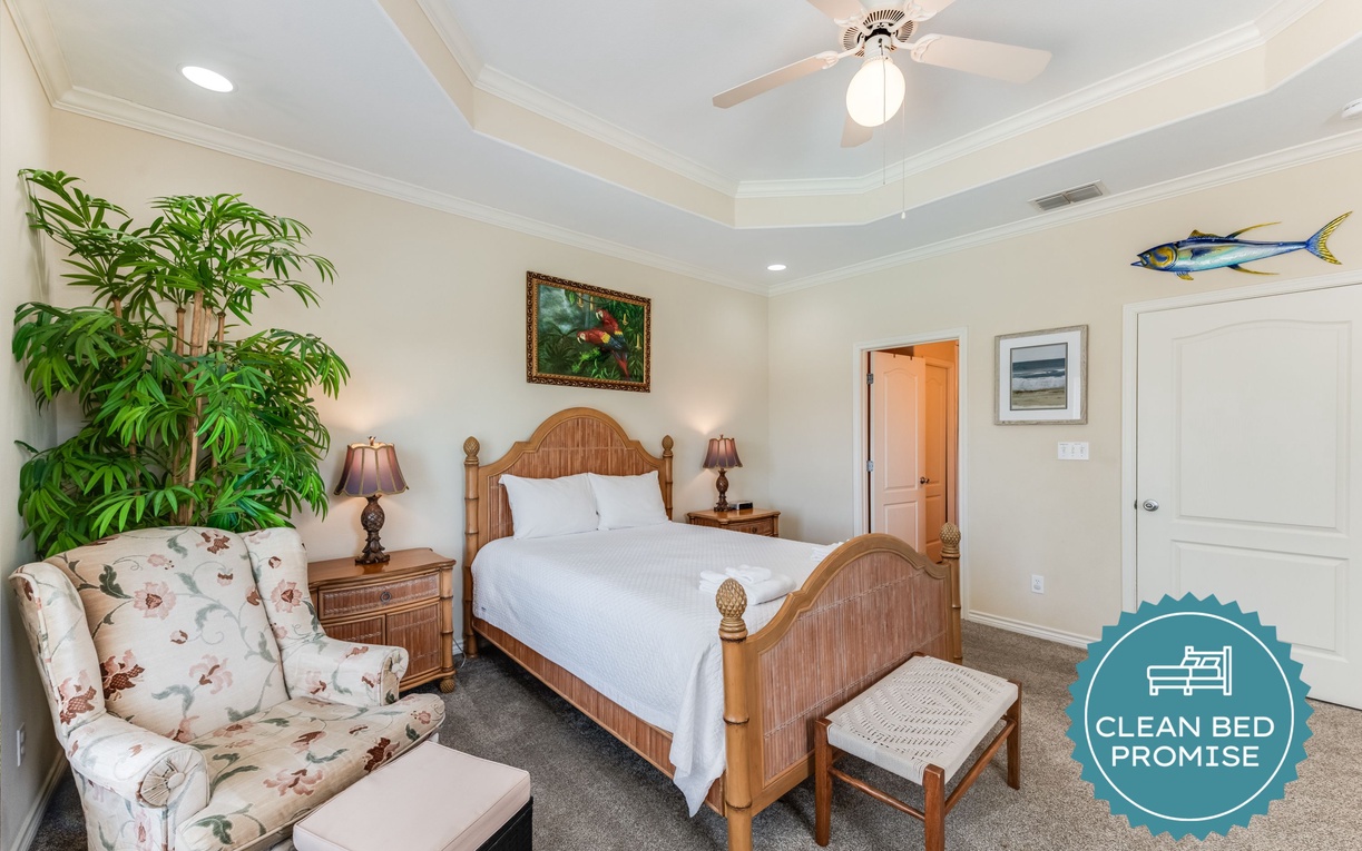 Relax in your coastal-inspired bedroom featuring a comfortable bed, cozy seating area, and tropical plant that creates a serene island getaway atmosphere.