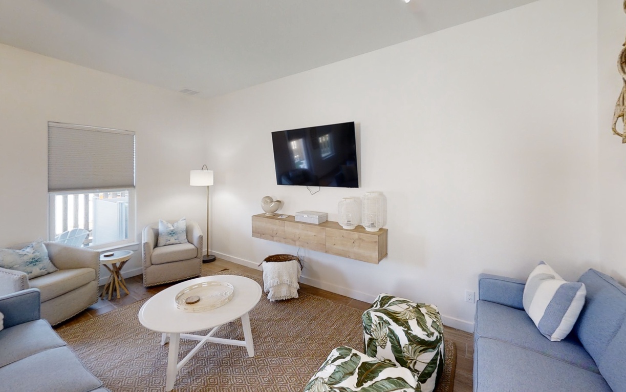 Unwind in your bright coastal living room with plush seating, modern TV, and nautical touches creating the perfect beachside retreat.