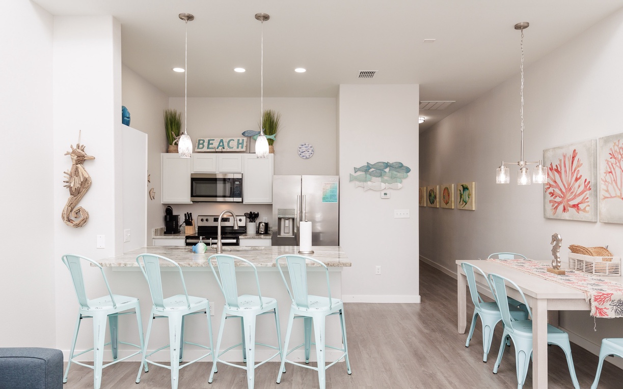 Gather around your coastal-inspired kitchen with mint bar stools and dining space, perfect for morning coffee and evening meals together.