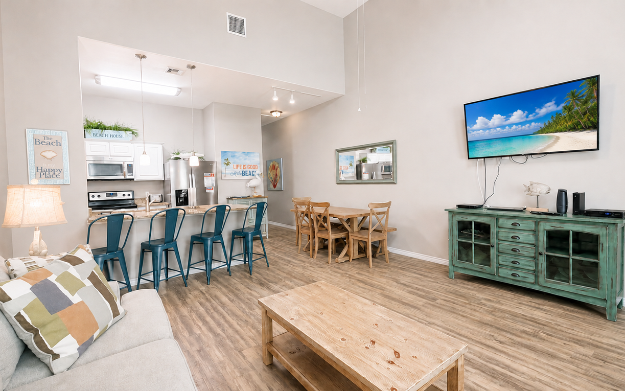 Relax and reconnect in this open living area, offering comfortable seating, a wall-mounted TV, and easy access to the kitchen and dining space.
