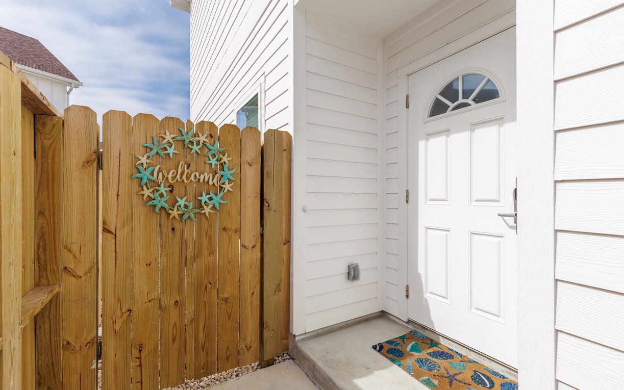 Charming white entrance with welcoming wreath greets you at arrival. The bright front door opens to your home away from home.