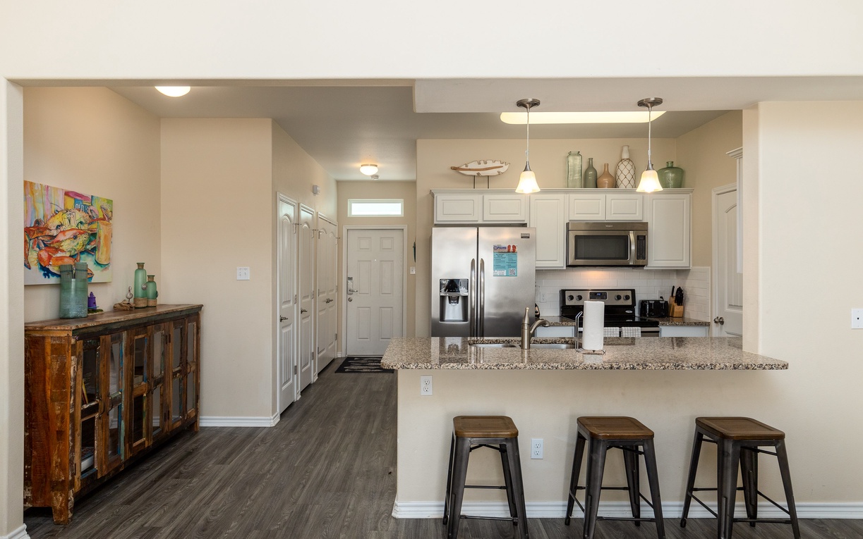 Your spacious open-plan kitchen welcomes you with granite countertops, stainless steel appliances, and a breakfast bar perfect for morning coffee.