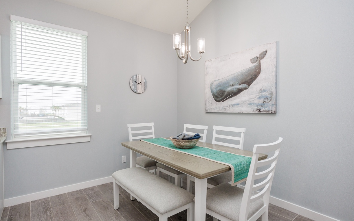 Gather around your bright dining table for morning coffee and evening meals, with coastal artwork setting a peaceful tone for memorable conversations.