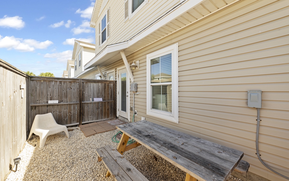 Your private patio offers a peaceful retreat with rustic wooden seating and gravel flooring, perfect for morning coffee or evening relaxation.