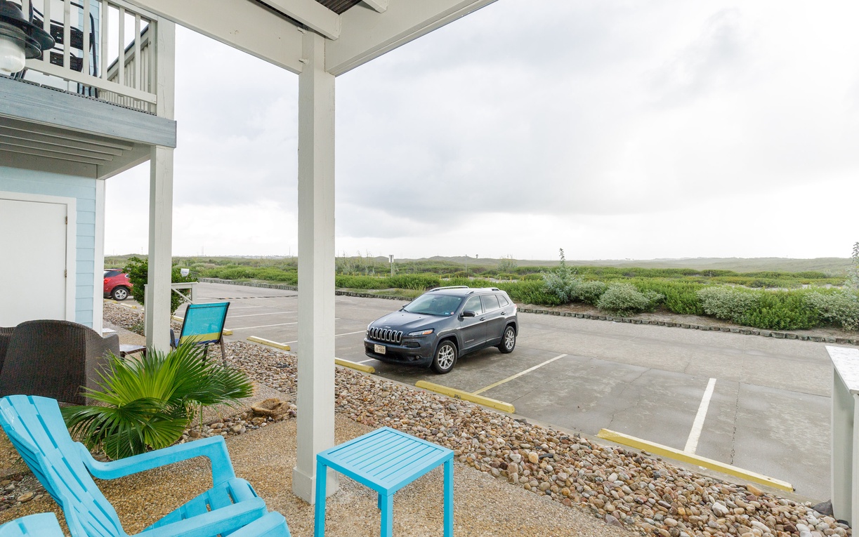 Step onto your private covered patio with turquoise seating overlooking the parking area and peaceful countryside beyond.