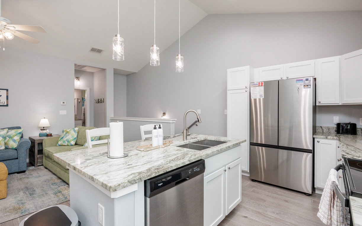 Your modern kitchen flows into the living area, featuring granite counters, stainless appliances, and stylish pendant lights perfect for evening meals.
