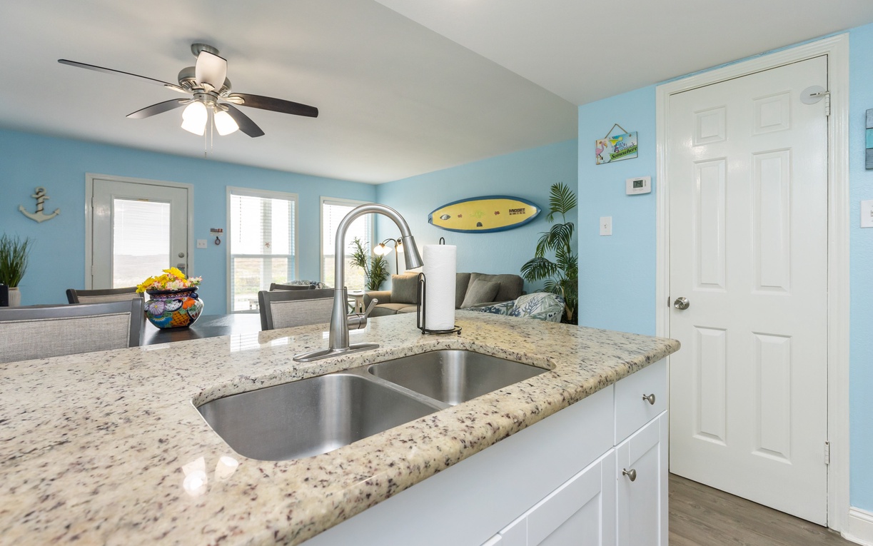 Your beachy kitchen blends coastal charm with modern convenience, featuring granite countertops and ocean-inspired decor that makes meal prep feel like a vacation.