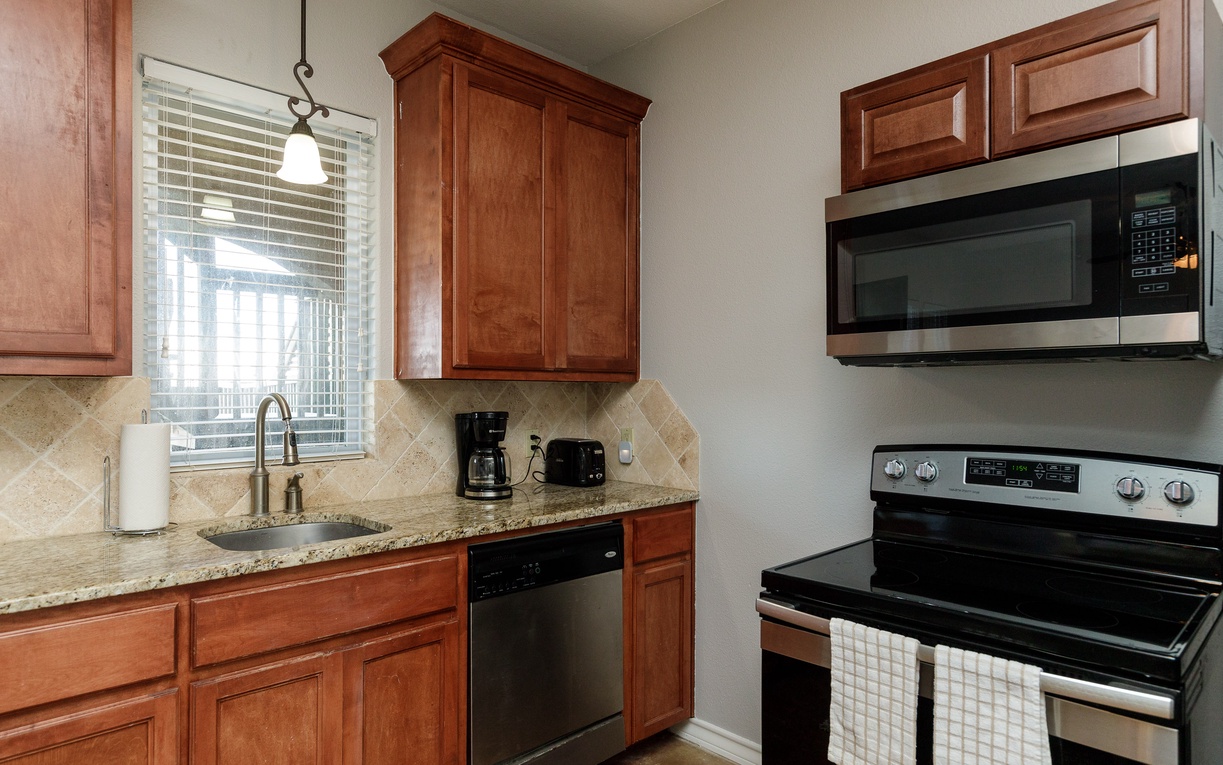 Your fully equipped kitchen features rich wood cabinetry, granite countertops, and stainless steel appliances for comfortable home-away-from-home cooking.