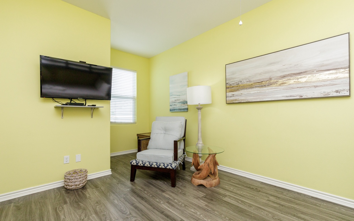 Unwind in your cheerful reading nook, where sunny yellow walls and a cozy striped chair create the perfect spot for morning coffee.