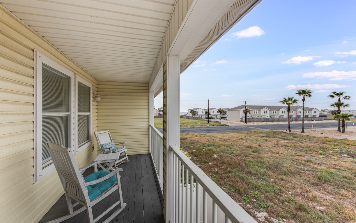 Relax on your private covered porch with comfortable seating, perfect for morning coffee while enjoying peaceful neighborhood views.