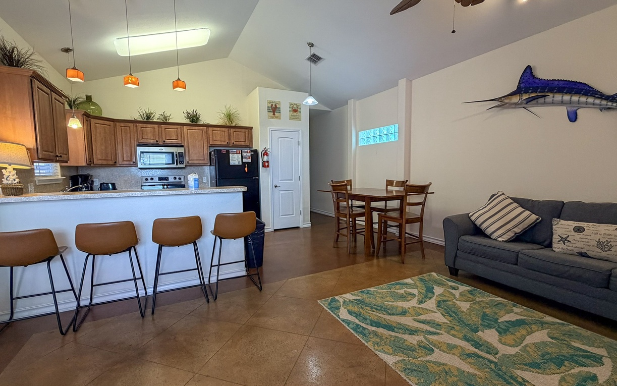 Your coastal retreat features an open kitchen, cozy dining space, and relaxing living area with nautical touches that make you feel at home.