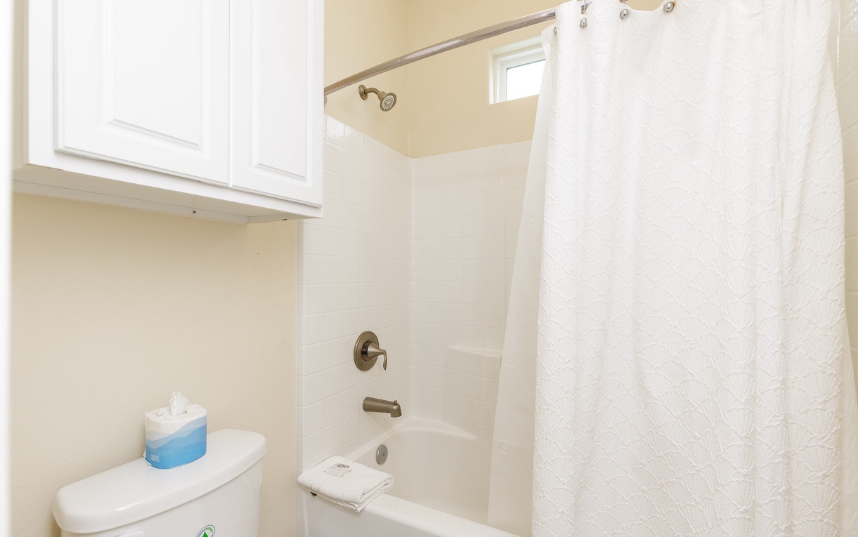 Step into your clean, bright bathroom with a spacious tub-shower combo, perfect for refreshing after your adventures.