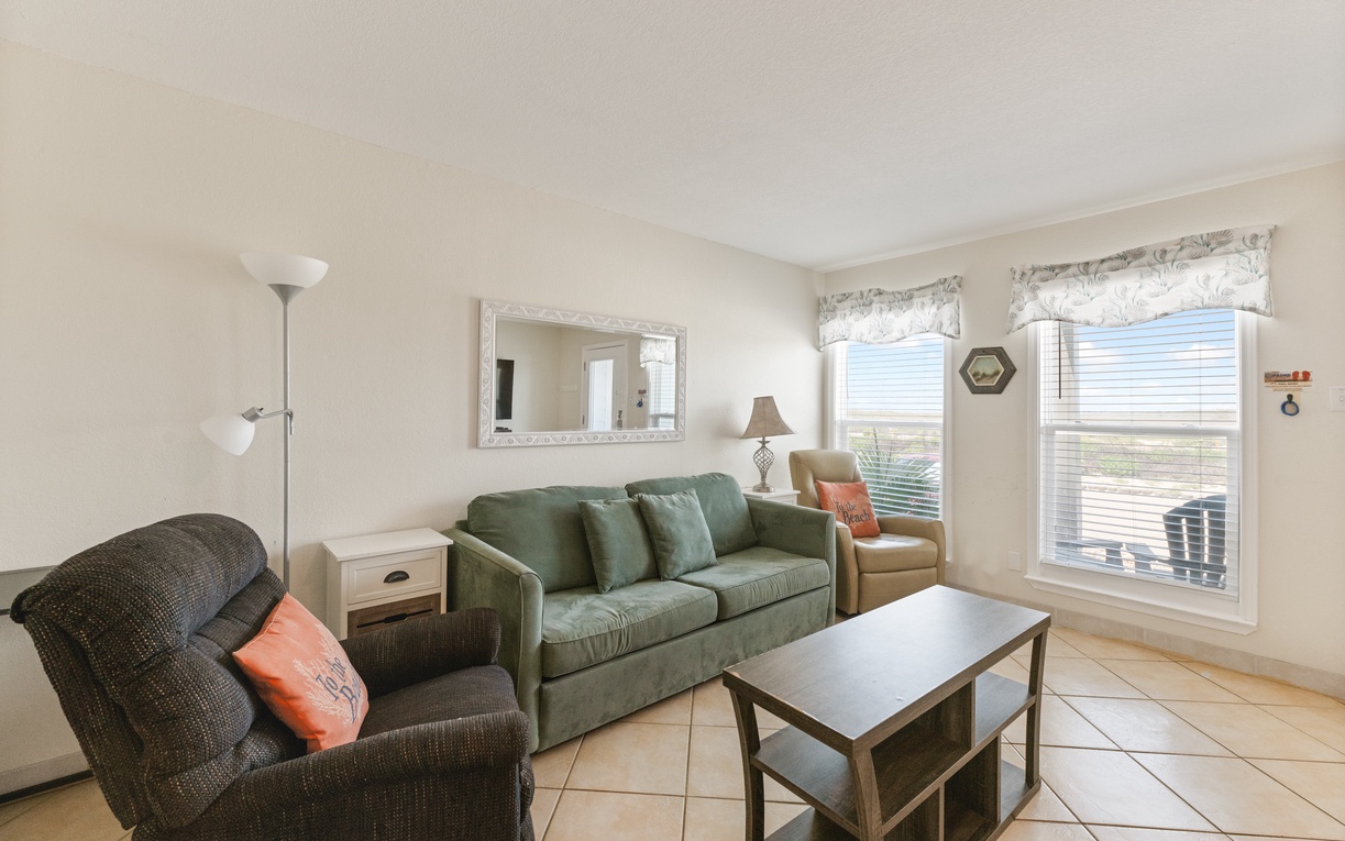 Unwind in your spacious living room with comfortable seating and natural light streaming through large windows.