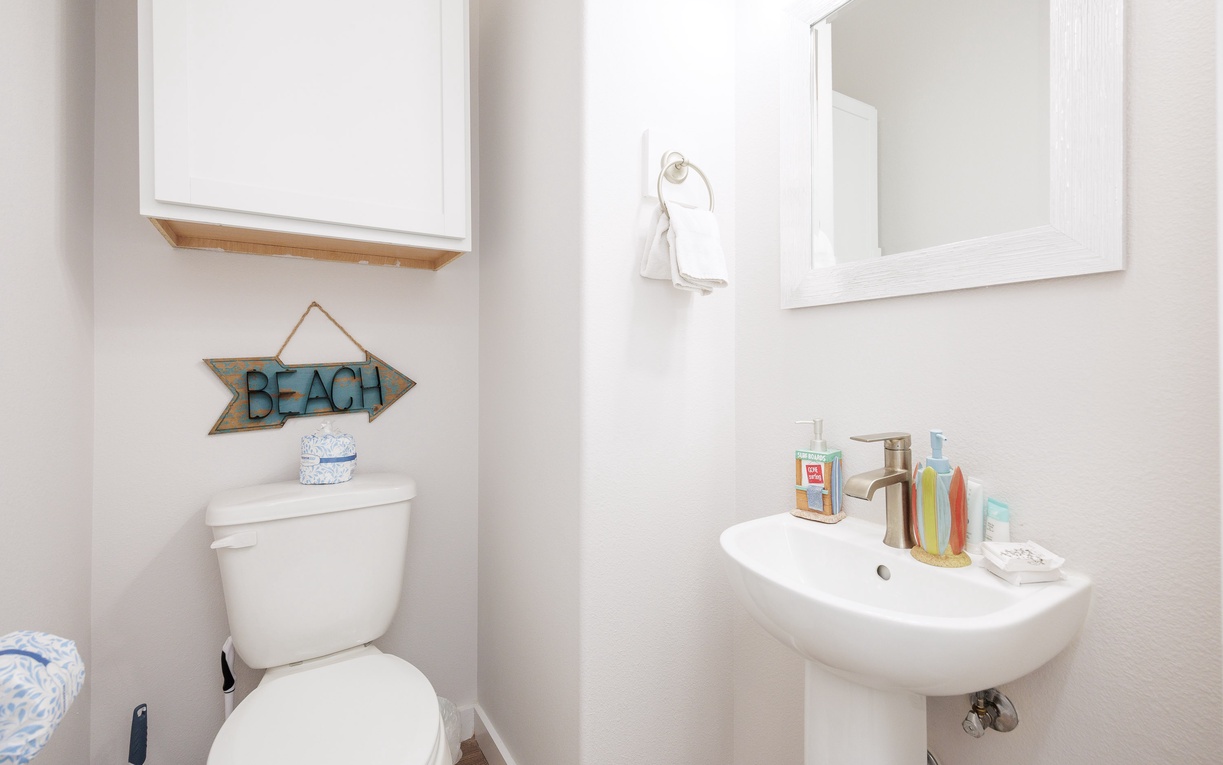 Your private powder room features a pedestal sink and charming beach-themed touches that add coastal charm to your morning routine.