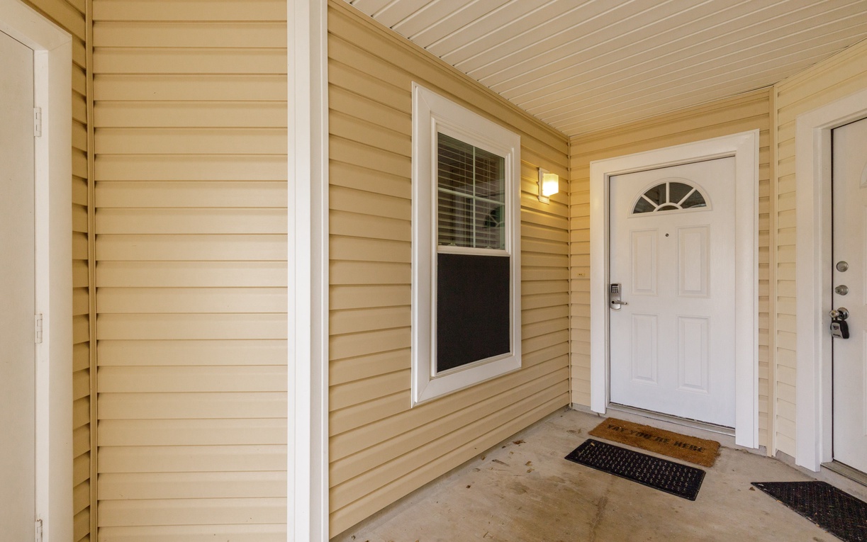 Your welcoming entrance features a covered porch with warm lighting, creating a cozy arrival experience at your home away from home.