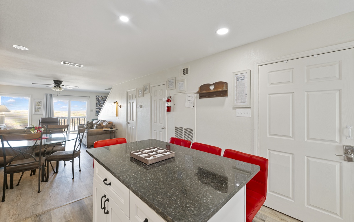 Your stylish kitchen island with bright red stools awaits morning coffee and meal prep, while windows frame scenic views.