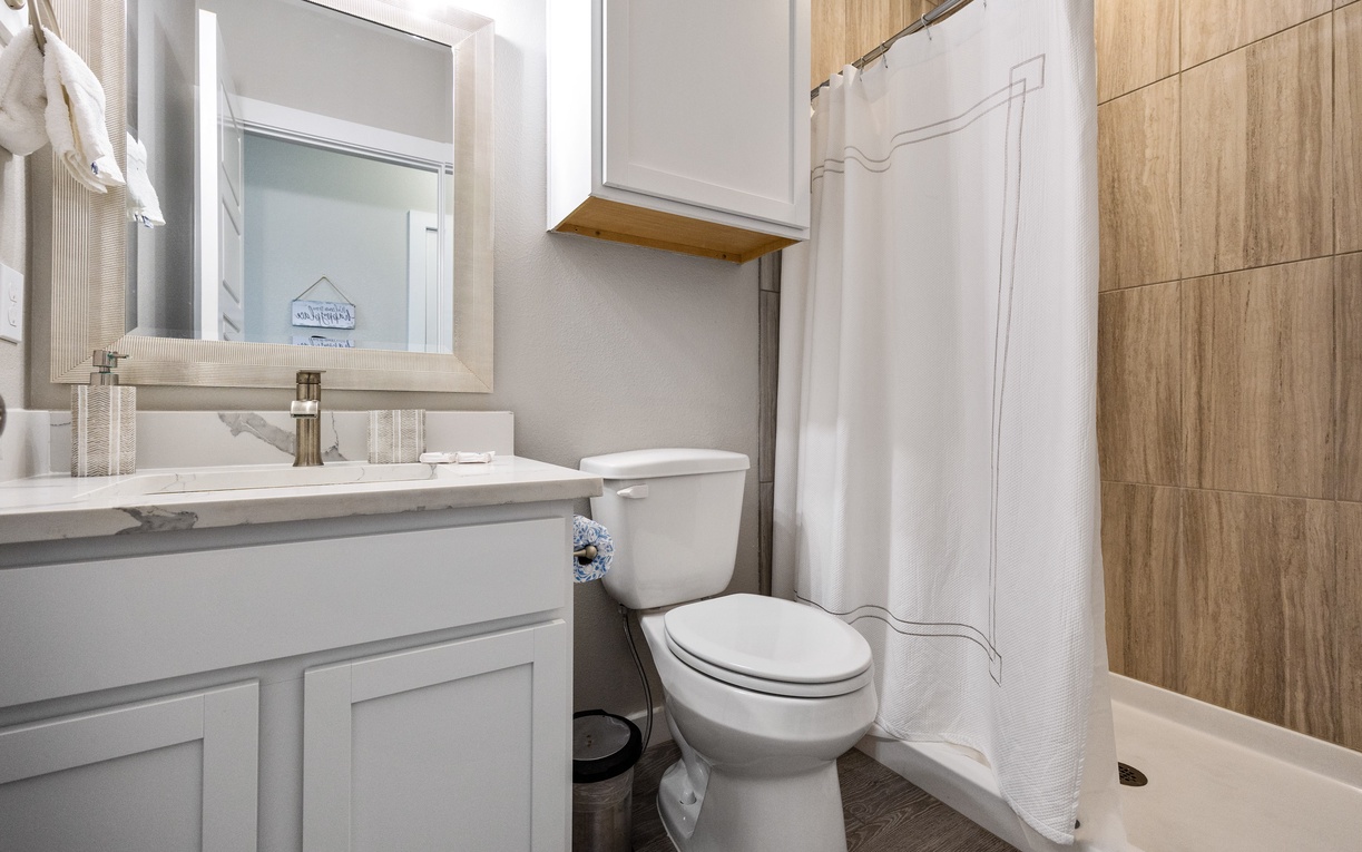 Your private bathroom combines modern fixtures with warm wood-grain accents, creating a spa-like retreat for your daily refresh.