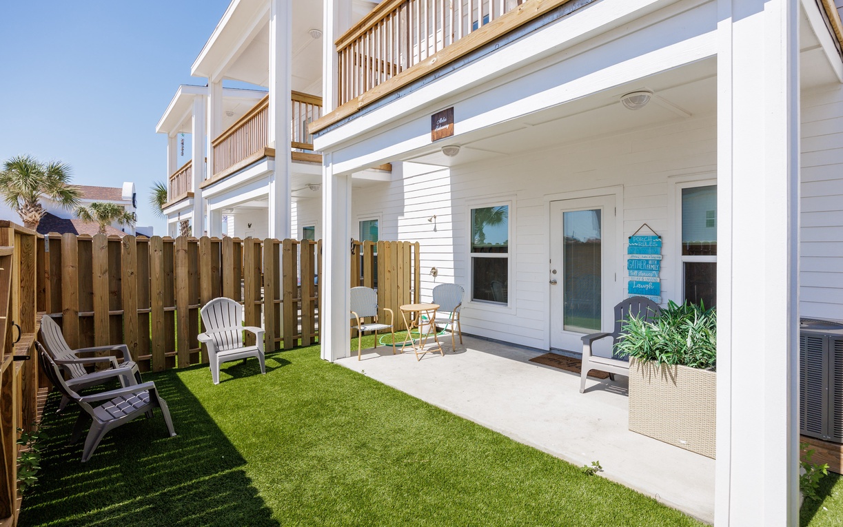 Your private patio beckons with comfortable seating and lush artificial turf, perfect for morning coffee or evening relaxation.