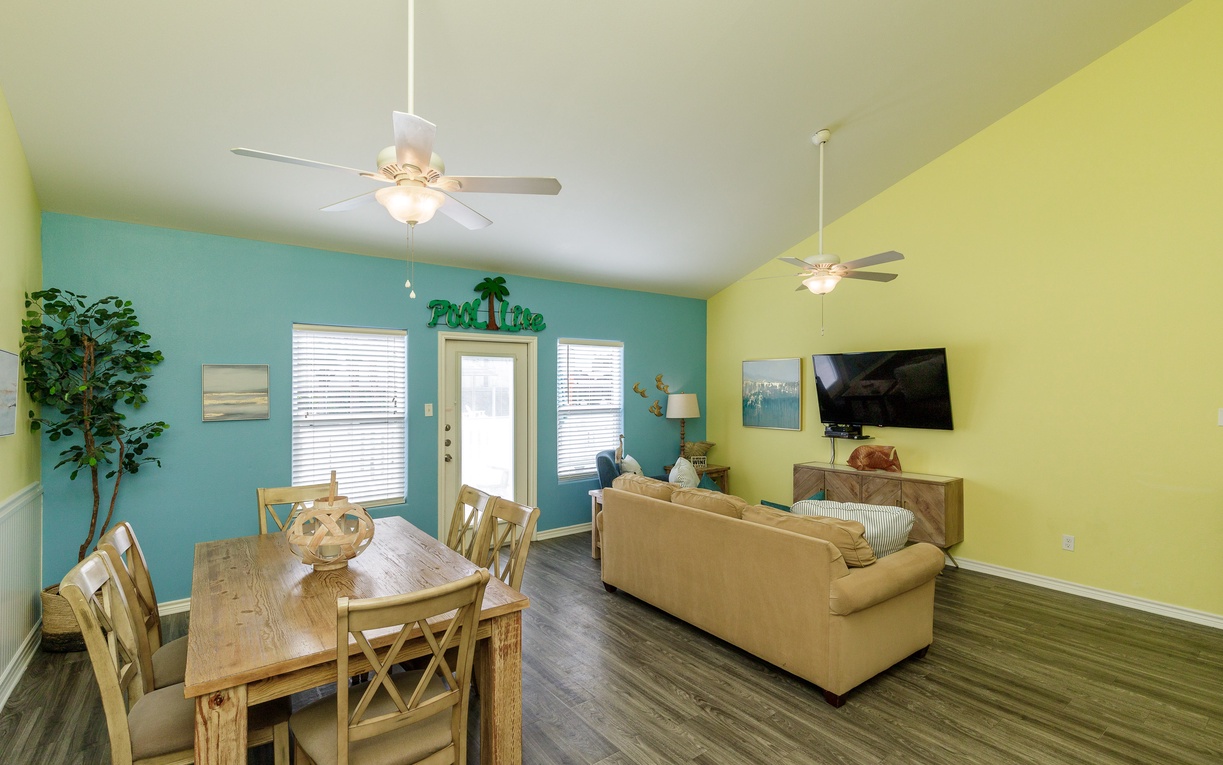 Bright tropical colors and comfortable furnishings create your perfect vacation retreat, with dining space and cozy seating under gentle ceiling fans.
