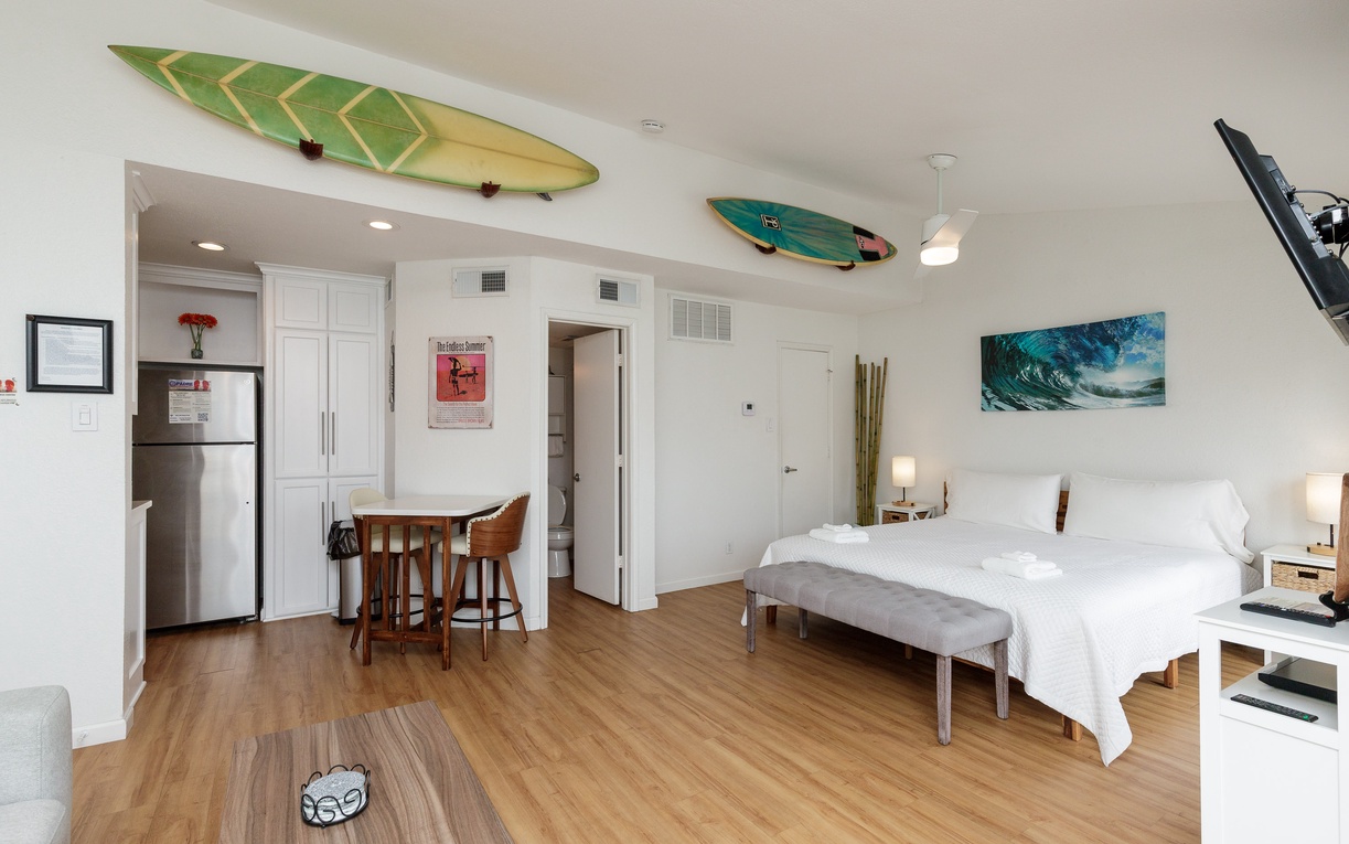 Your surf-inspired studio blends coastal charm with modern comfort, featuring surfboards overhead and ocean artwork to inspire your beachside adventures.