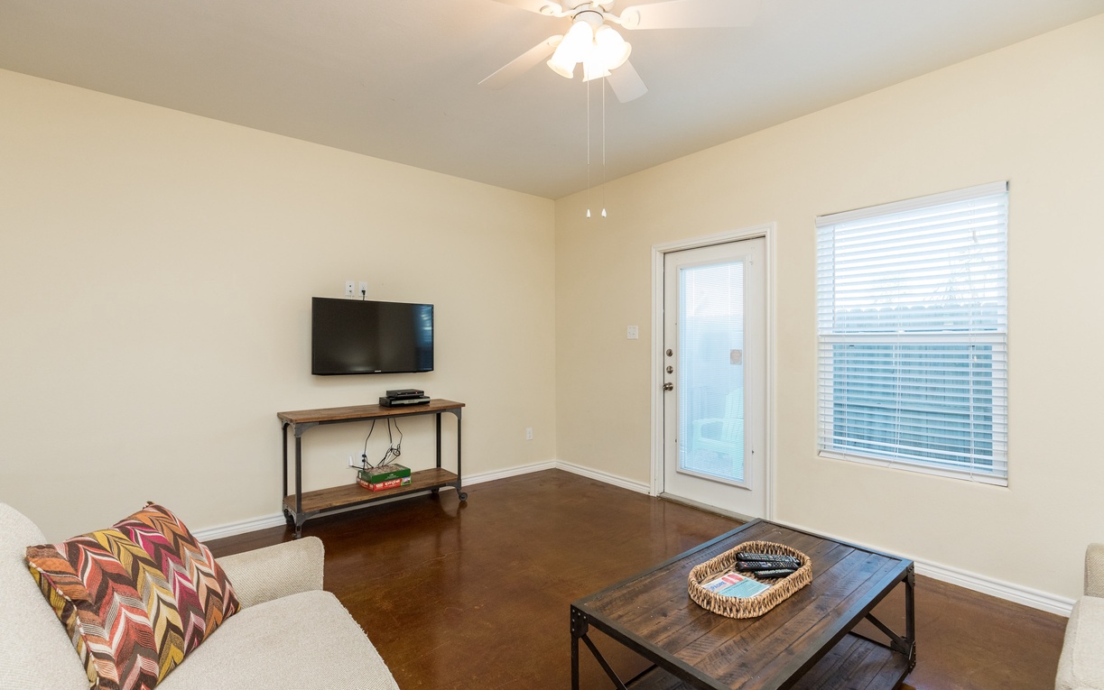 Relax in your bright living space with comfortable seating, modern TV entertainment, and French doors opening to your private outdoor area.