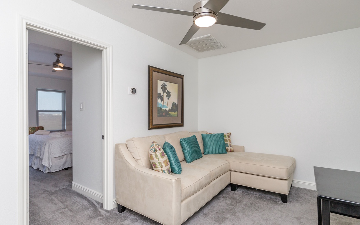 Relax in your bright living space with plush seating and coastal decor, just steps from your cozy bedroom retreat.