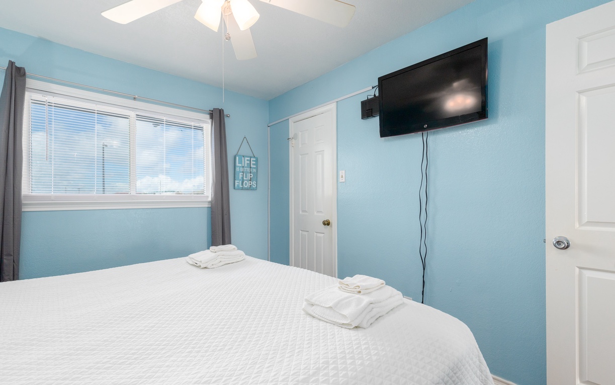 Unwind in your serene blue bedroom with crisp linens and beachy vibes perfect for coastal relaxation.