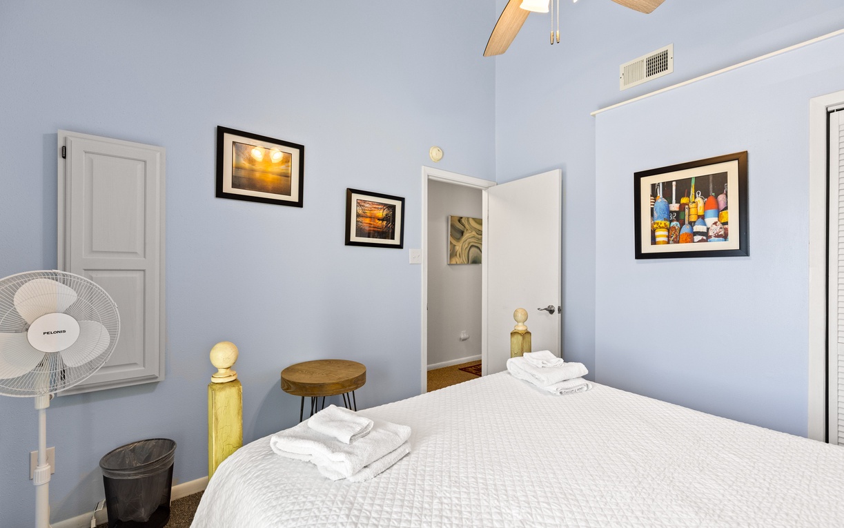 Drift off in your serene blue bedroom, where fresh towels await and artwork creates a welcoming atmosphere.