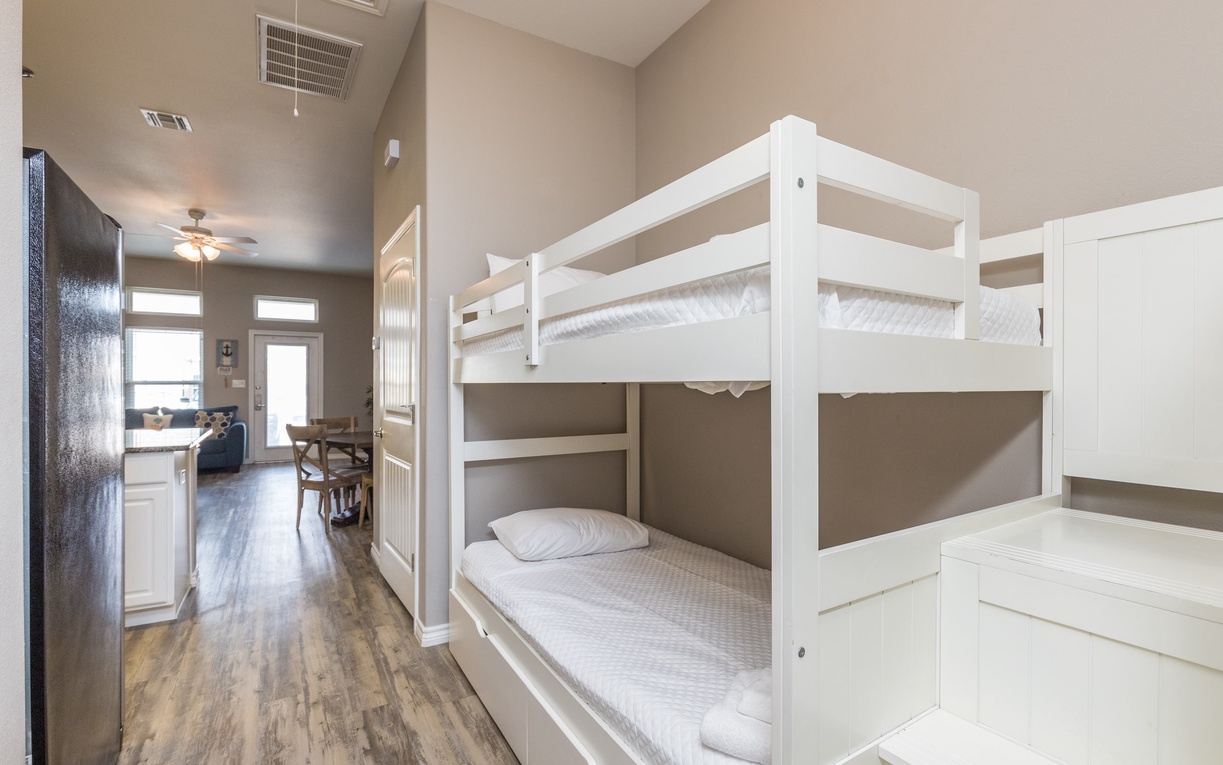Your comfortable bunk room features fresh white beds and connects to the open living area - perfect for families or groups traveling together.